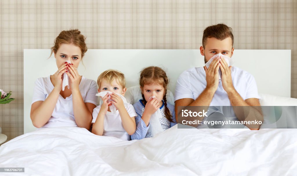 colds and viral diseases. family with runny nose and fever in bed colds and viral diseases. family with runny nose and fever in bed at home Cold And Flu Stock Photo