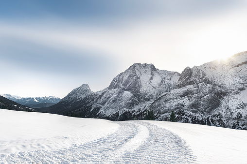 Alpine winter landscape with snowy mountains and snowy road