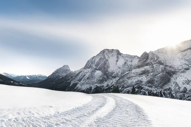 Alpine winter landscape with snowy mountains and snowy road stock photo
