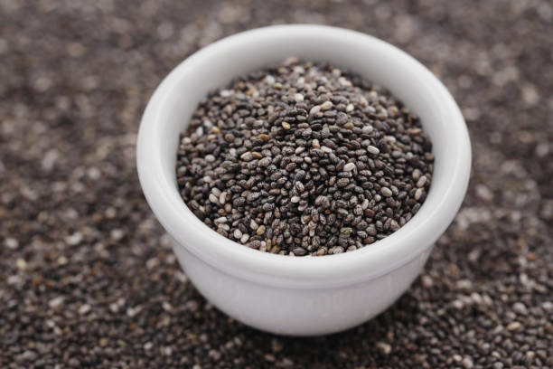 Organic Chia Seed Organic Chia Seed, super food in a bowl with background salvia hispanica plant stock pictures, royalty-free photos & images