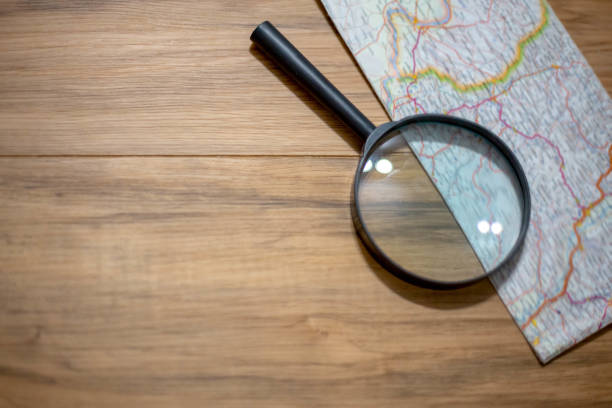 istock Old notebook, compass, map, vintage binoculars, magnifying glass on wooden background 1182709319