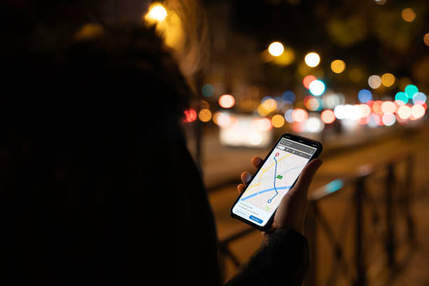 istock Woman is looking at map on smart phone at night 1182710352