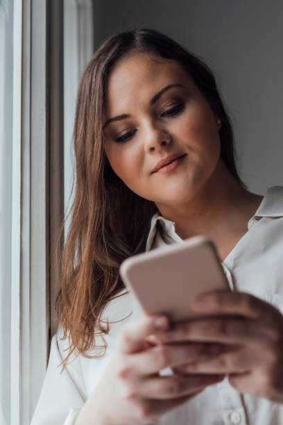 istock Pretty Plus Size Woman Using her Cell Phone 1182710509
