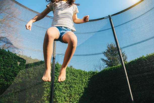 istock little girl jumping high on trampoline 1182714257
