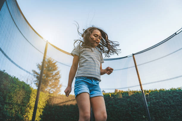 istock little girl jumping high on trampoline 1182714308