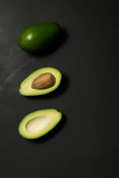 istock Fresh, raw avocado sliced on a black 1182714349