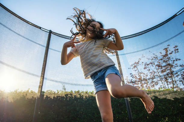 istock little girl jumping high on trampoline 1182714400