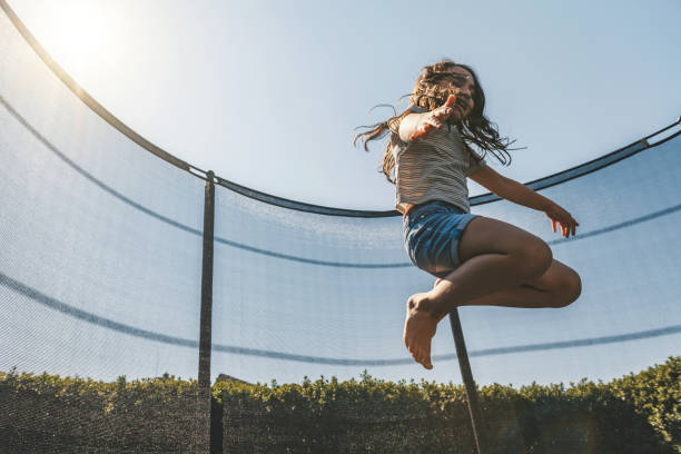 istock little girl jumping high on trampoline 1182714462