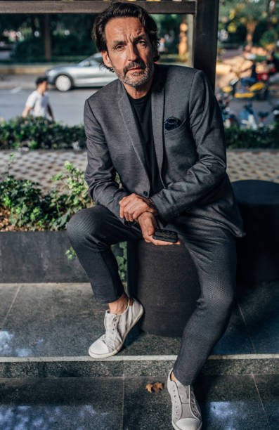 istock Mature businessman in gray suit text messaging 1182717018