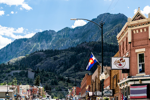 Ouray, USA - August 14, 2019: Small town in Colorado with city main street and San Juan mountains peak view by historic architecture