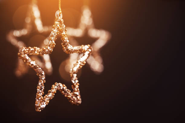 Golden Christmas stars on dark background.