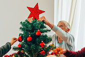 Senior woman decorating the Christmas tree