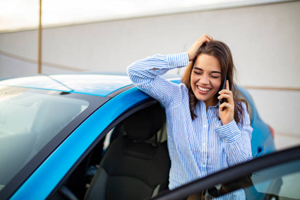 istock Business Woman Uses Smartphone While Leaning on Her Car 1182723852