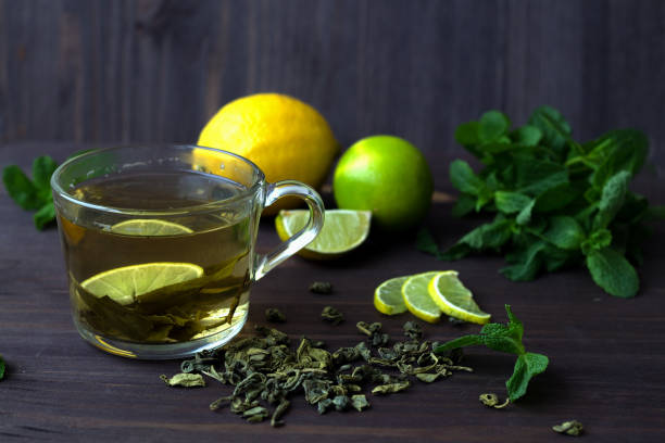 filiżanka zielonej herbaty z cytryną na drewnianym tle - leaf cup breakfast drink zdjęcia i obrazy z banku zdjęć