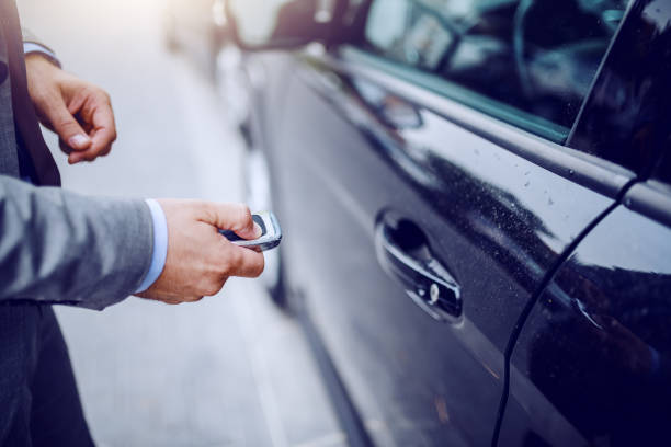 close up of man unlocking his car on rainy weather. - key ring fotos imagens e fotografias de stock