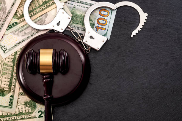 Bail bond system, bailing out of jail and innocent until proven guilty conceptual idea with judge wooden gavel, dollar banknotes and handcuffs with copy space Bail bond system, bailing out of jail and innocent until proven guilty conceptual idea with judge wooden gavel, dollar banknotes and handcuffs with copy space bail stock pictures, royalty-free photos & images