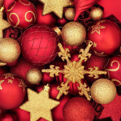 Red and gold Christmas tree decorations forming an abstract background. Traditional symbols for the festive season.