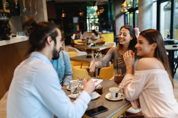 istock Two young men meet two young women in a cafe 1182731503