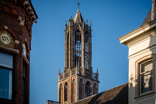 Dom cathedral tower Utrecht up in the air high with blue sky in the afternoon sun at sunset