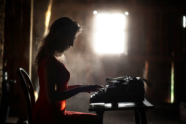 istock A girl in retro style prints on an old typewriter 1182734632