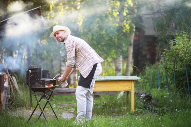 istock A man prepares a barbecue in nature 1182735242