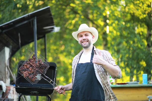 istock A man prepares a barbecue in nature 1182735338