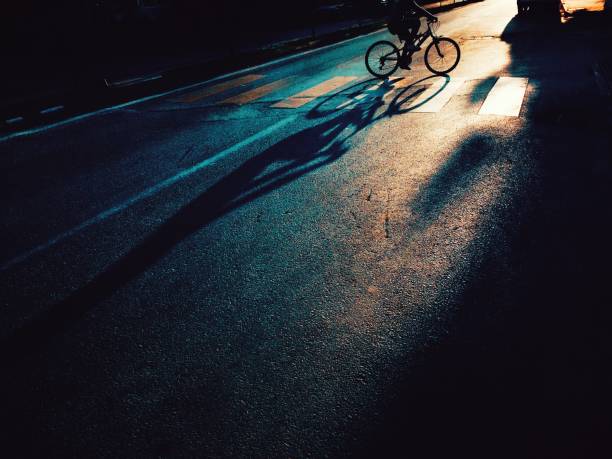 istock Cyclist on urban road at sunset 1182736869