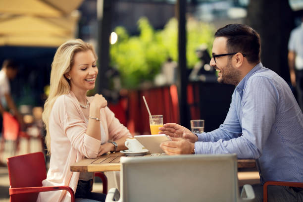 istock Happy couple using touchpad while relaxing in a cafe. 1182740994