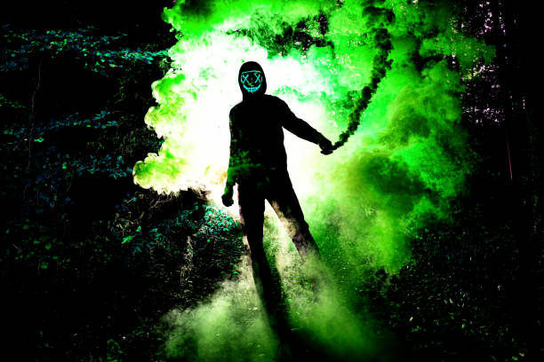 Portrait Of Man Holding Distress Flare With Green Smoke