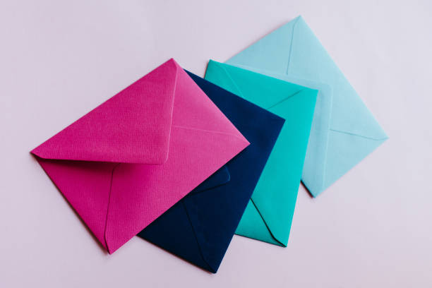 istock Colored paper envelopes on a light background. New mail, write message. Send and receive letter. Postal delivery service. Blank envelope, empty space. People communication, paperwork. Envelope closeup 1182745156
