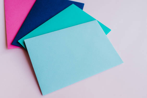 istock Colored paper envelopes on a light background. New mail, write message. Send and receive letter. Postal delivery service. Blank envelope, empty space. People communication, paperwork. Envelope closeup 1182745159