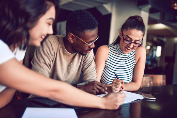 istock Multiethnic Friends Writing Homework Together 1182745603