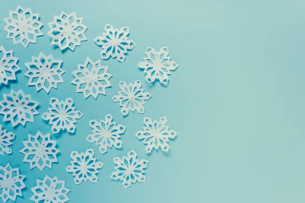 istock Paper snowflakes on blue background 1182745795