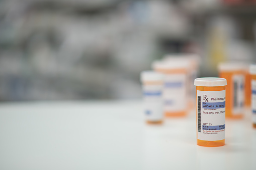 Multiple prescription pill bottles standing scattered on a counter
