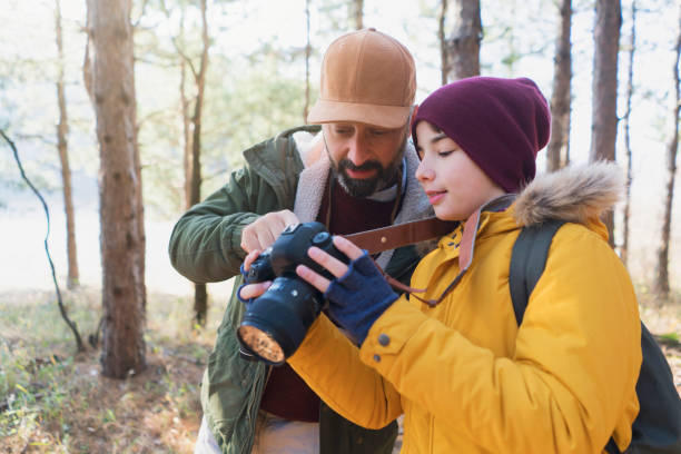 Father teaches his son how to use a camera