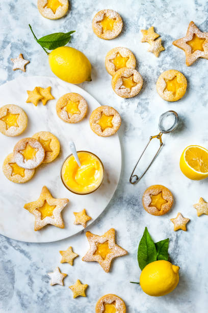istock Linzer Christmas cookies filled with lemon curd and dusted with sugar on white marble board 1182750455