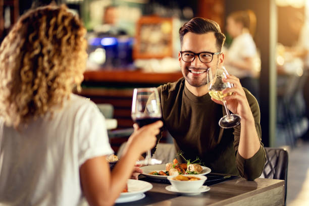 istock Happy couple communicating while drinking wine and eating in a restaurant. 1182753026