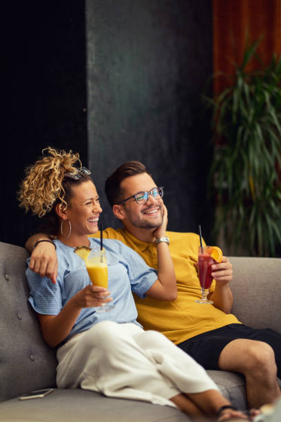 joven pareja feliz con cócteles de frutas disfrutando en su tiempo juntos. - home interior cocktail bar women fotografías e imágenes de stock