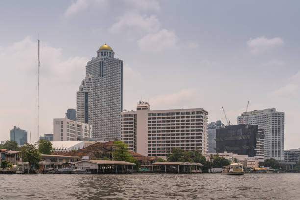 Bangkok city, Thailand - March 17, 2019: Chao Phraya River. Three hotel towers and another one under construction: State Tower with golden dome housing Lebua, and Mandarin Oriental and Shangri-la.