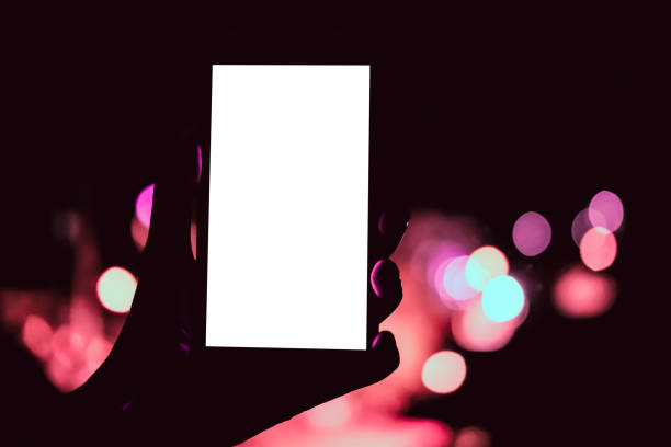 istock hand holding mobile smart phone with bokeh night light 1182762357