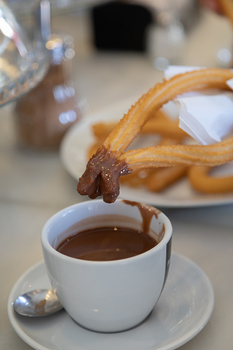 Churros with hot chocolate in restaurant