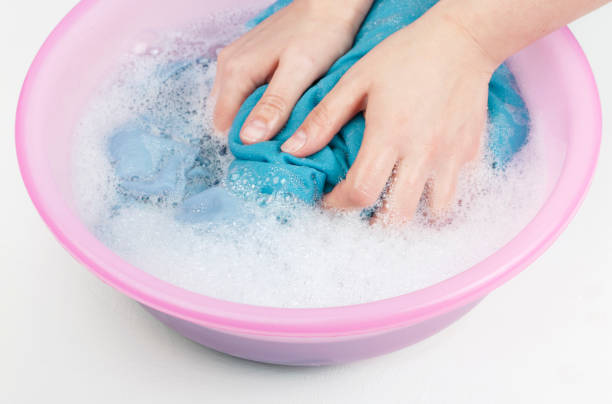 istock Female hands washing white and blue clothes in basin 1182769183