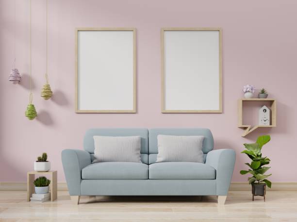 istock Interior poster mockup with vertical empty wooden frame standing on wooden floor with sofa on pink background. 1182769194