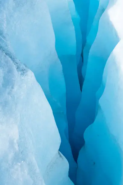 Deep crevasse layered through blue ice of the Salmon Glacier. Deep in the Boundary Range separating Canada and Alaska.
