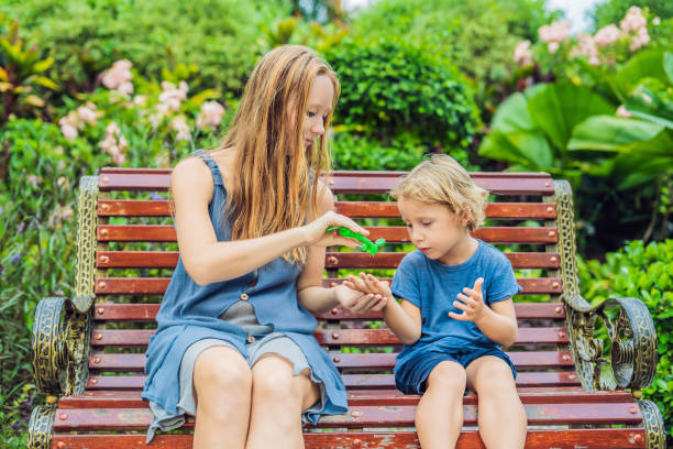 mother and son using wash hand sanitizer gel in the park before a snack - 4622 imagens e fotografias de stock