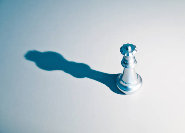 istock Silver chess queen with the shadow of a king 1182776064