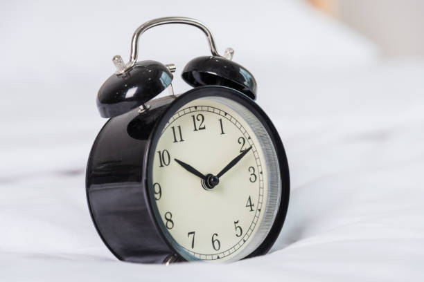 istock Black Alarm clock at 8 am on the bed 1182779072