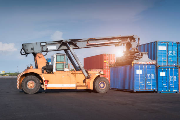 istock Forklift truck lifting Cargo containers in shipping dock yard for import,export 1182779076