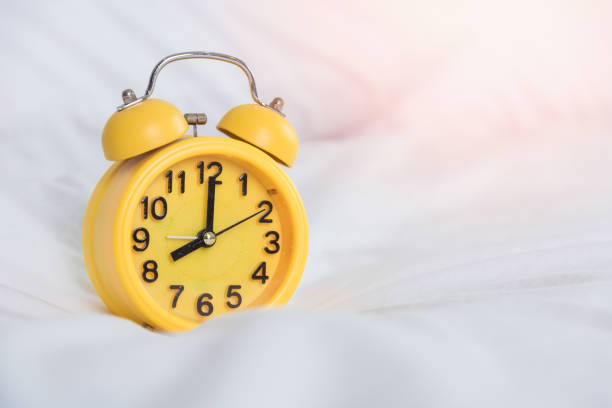 istock Yellow Alarm clock at 8 am on the bed 1182779887