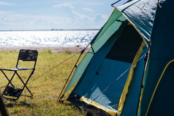 istock Camping green tent near lake, 1182780043